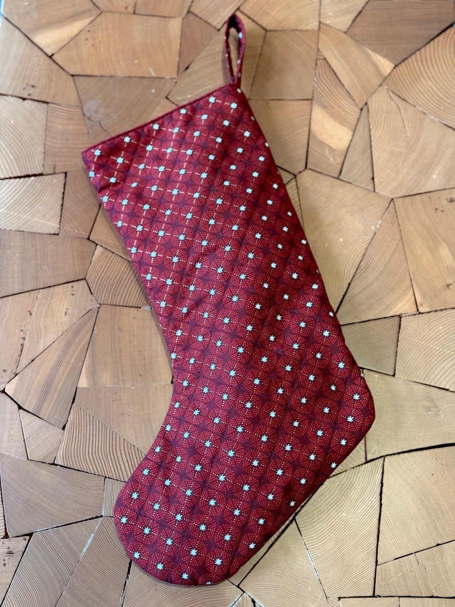 A red stocking on a wooden table. 